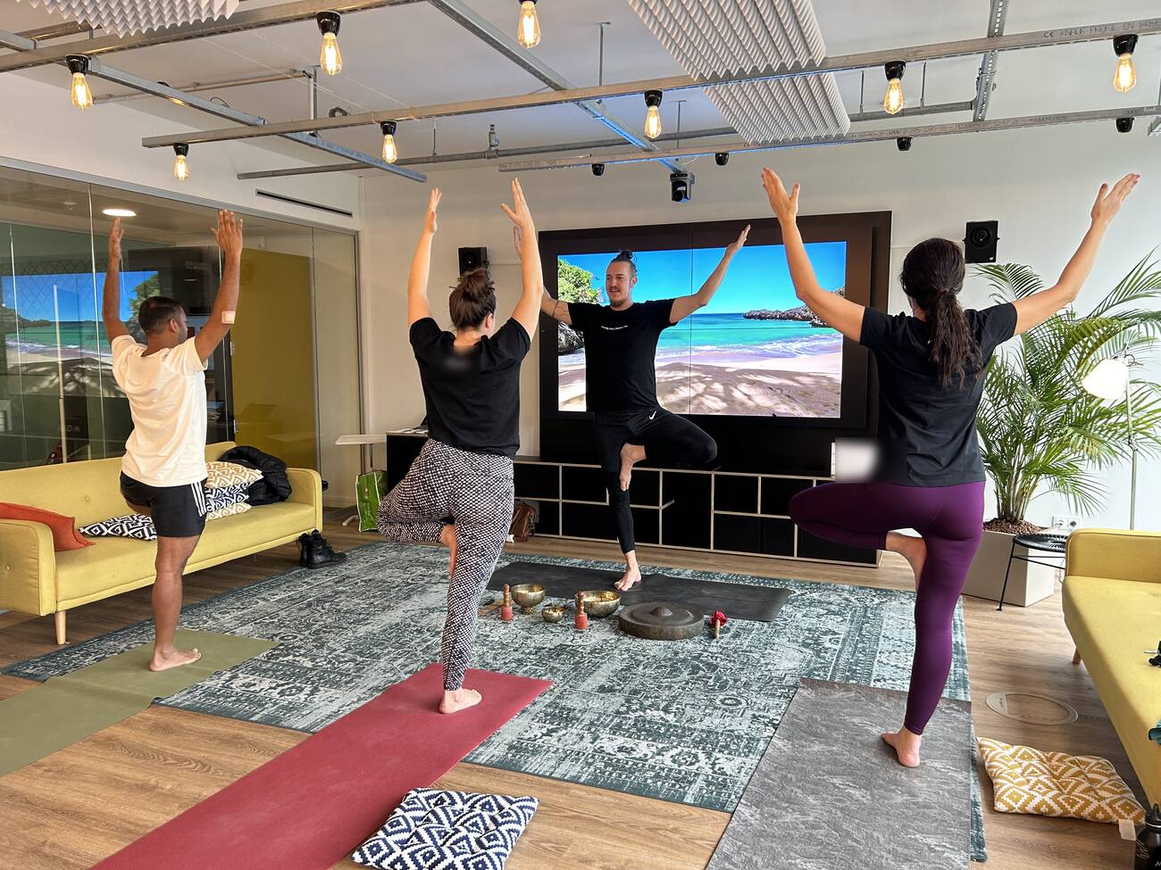 Yogastunde im Büro, vier Menschen im Baum, Klangschalen auf dem Boden